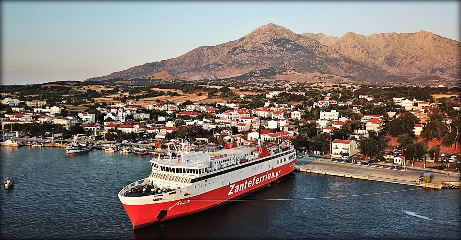 Ege denizinde seyreden mavi beyaz gövdeli arabalı yolcu feribotu