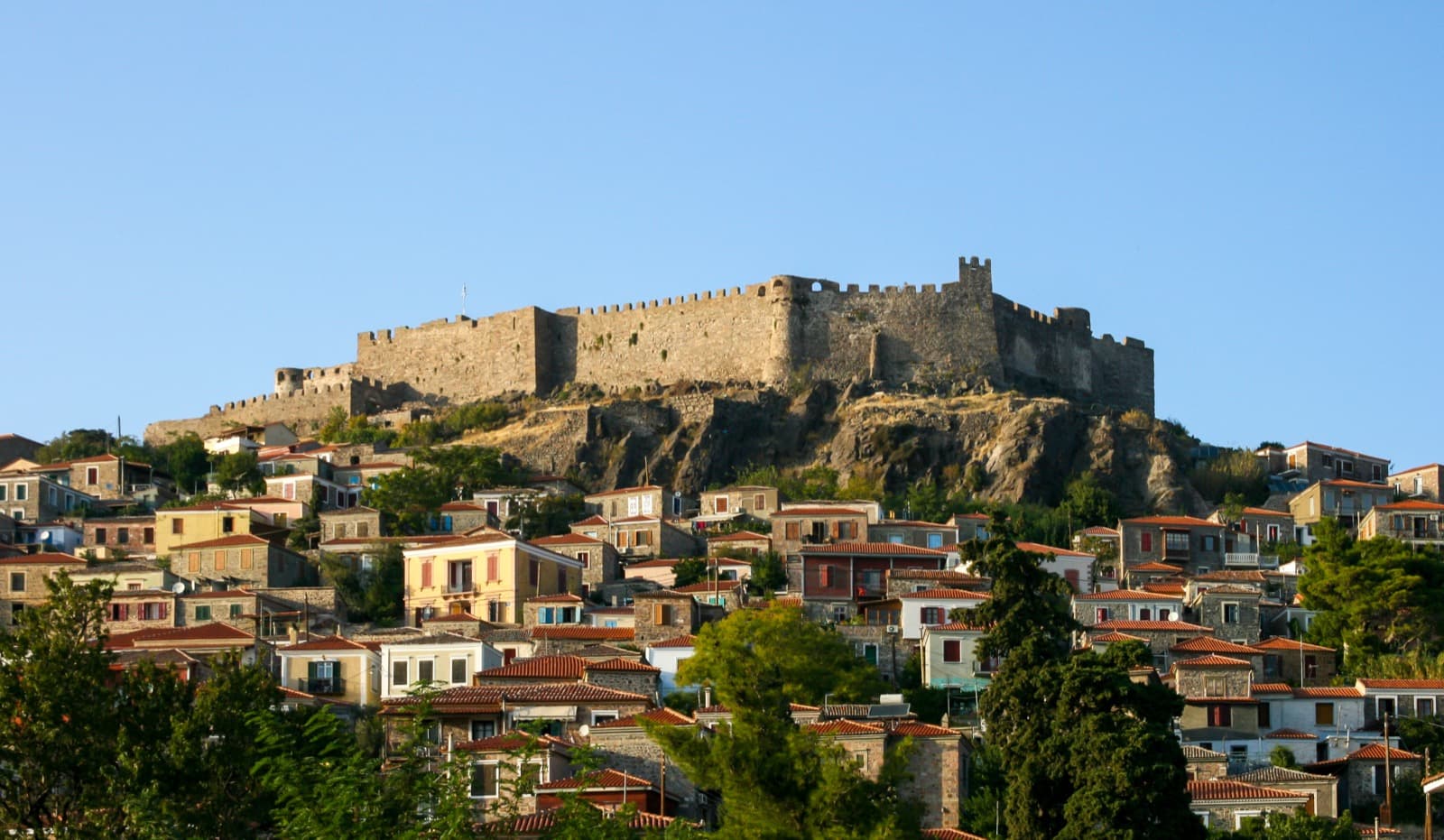 Molyvos kasabasında tepedeki Bizans kalesinin altına dizilmiş taş evler ve liman